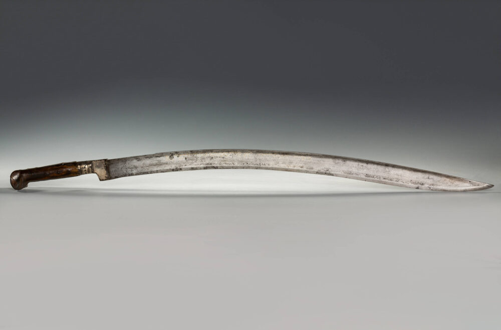 Türkischer Säbel, ein sogenannter Yatağan, mit braunem Knauf und silberfarbener, etwas abgestumpfter Klinge.