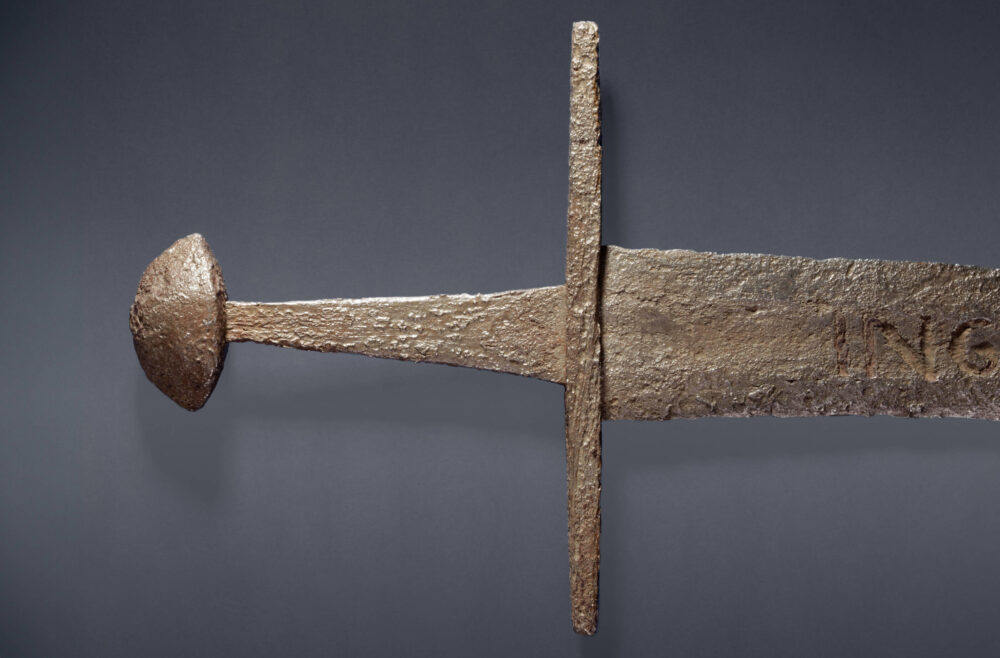 Detailbild eines Ingelrii-Schwertes vom Knauf bis zum Beginn der Inschrift an der Klinge.