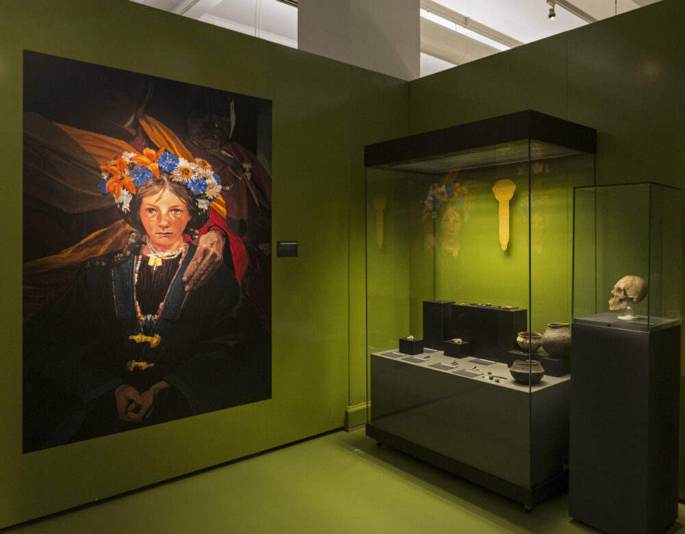 Blick in eine archäologische Ausstellung mit Vitrinen und dem Bild eines Mädchens in frühmittelalterlicher Tracht.