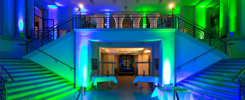 Das Foyer und die Empore im ersten Obergeschoss des Landesmuseums mit grün-blaufarbener Festbeleuchtung.