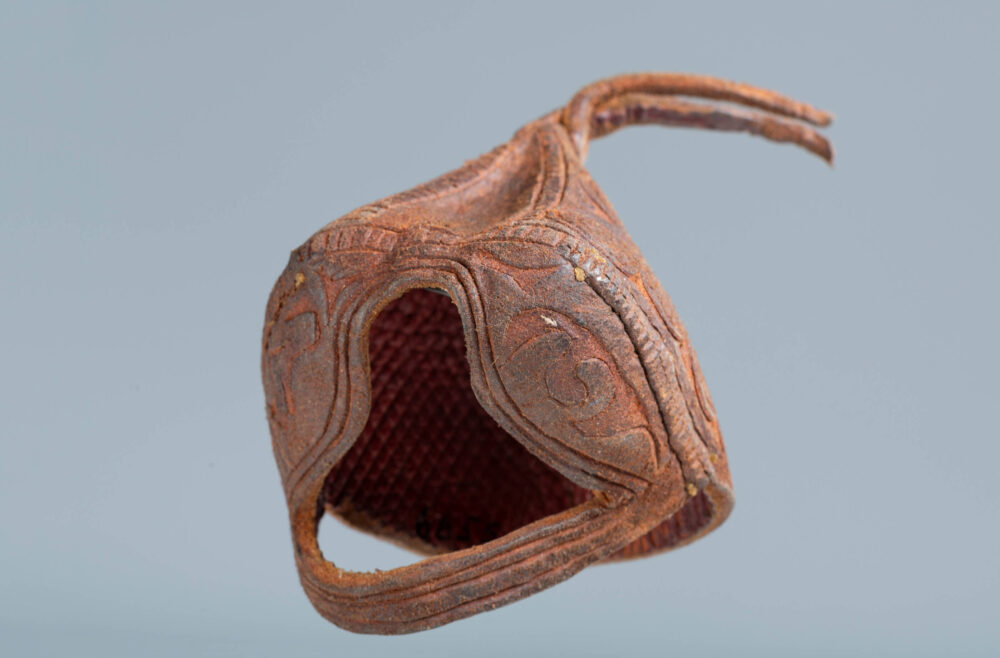 Foto einer Lederhaube aus Kirgistan für Adler in rot-bräunlicher Färbung.